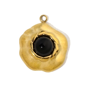 Detailed view of a gold flower pendant with a black stone inlay and a top hanging loop