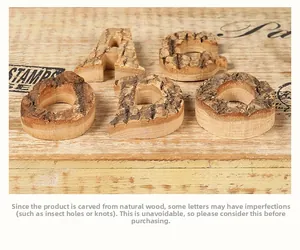 Close-up of natural birch wood alphabet letters with bark texture and tree ring patterns