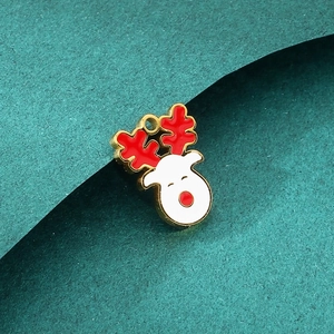 Macro view of a gold Christmas elk pendant with red antlers on a dark green background