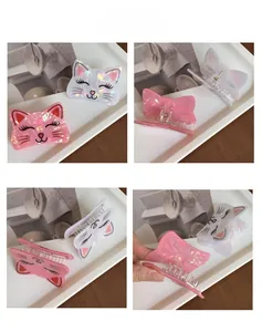 Détail des pinces à cheveux chat en acrylique aux finitions rose et blanc nacré