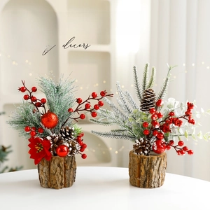 Mini Christmas tree with flocked snow, red berries and pinecones in a rustic wood bark pot