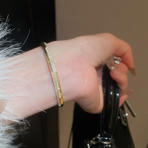 Gros plan d'un bracelet plaqué or 18 carats avec doubles rangées de zircons pavés