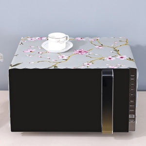 Detailed laser-cut wavy edge on grey linen microwave cover with pink cherry blossoms