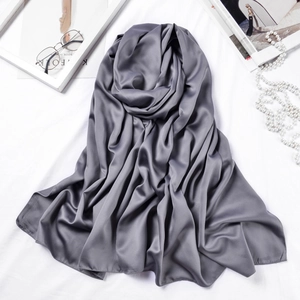 Detail view of a gray silk satin scarf with elegant draped texture and matte finish