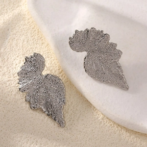 Macro shot of silver ginkgo leaf stud earring with detailed metallic leaf texture