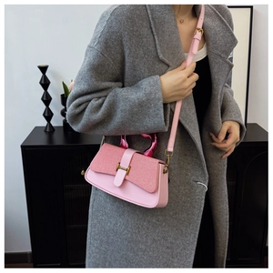 Detail of pink box bag with woven texture lid and elegant golden H-shaped hardware buckle