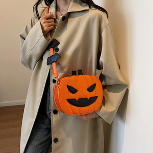 Funny pumpkin crossbody bag with orange leather texture and black bat strap detail