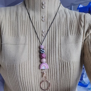 Silicone beaded lanyard with rainbow pendant and metal keychain worn by a model