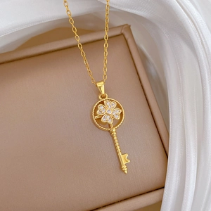 Close-up of golden spinning lucky key necklace with sparkling clover inlay on leather case