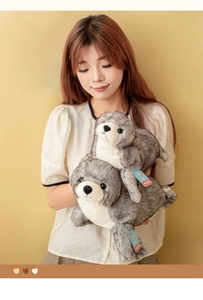 Vista dettagliata di grandi e piccoli peluche a forma di foca con morbida pelliccia grigio-bianca
