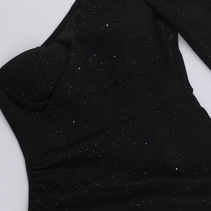 Vista detallada de la tela negra brillante con cremallera invisible y drapeado fino