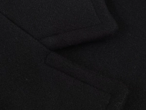 Detail shot of the fine stitching and thick wool blend fabric on a black casual coat