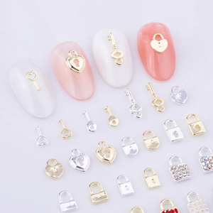 Vue détaillée de bijoux d'ongles avec clés vintage, cadenas cœur et perles nacrées