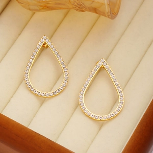 Elegant gold hollow teardrop earrings with white zircon inlays on a jewelry box
