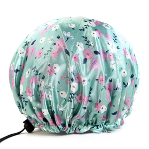 Detail of adjustable shower cap with floral satin fabric and black sizing buckle