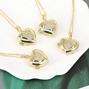 Gold heart locket necklace collection featuring hamsa, evil eye, and butterfly zircons