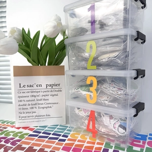 Detail of 4-tier clear stackable storage boxes with numbered labels for stickers and crafts
