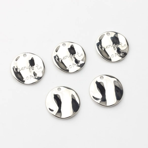 Five round silver-plated metal pendants with engraved text on a clean white background