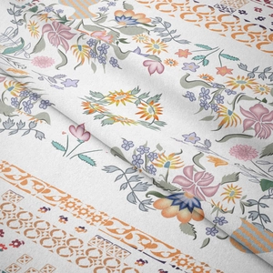 Detailed macro view of soft white tapestry fabric with vibrant floral and geometric patterns