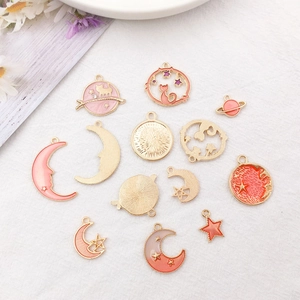 Detailed view of pink and orange enamel celestial charms for jewelry making