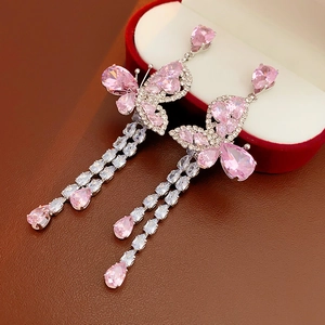 Detailed shot of pink butterfly earrings with long tassels on a velvet jewelry box