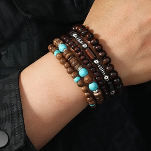 Detail view of four-piece layered men's handmade beaded bracelets with wood and turquoise