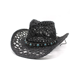 Detail of black woven straw cowboy hat with gemstone belt and intricate cutout textures