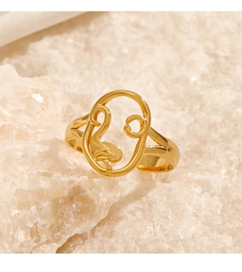 Macro detail of 18K gold-plated stainless steel ring with abstract hollow face design