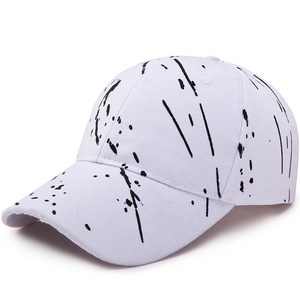 White baseball cap with black ink splatter pattern in a modern six-panel curved brim design