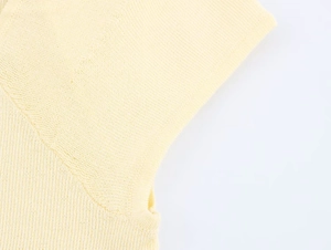 Close-up of pale yellow knit texture showing detailed stitching and fabric quality