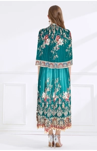 Rear view of pleated chiffon vacation dress with dark green floral prints and silver heels