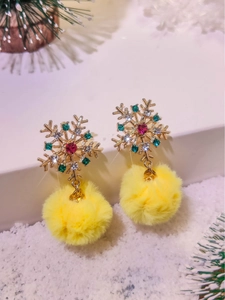 Detailed view of golden snowflake earrings with colorful rhinestones and yellow pom-poms
