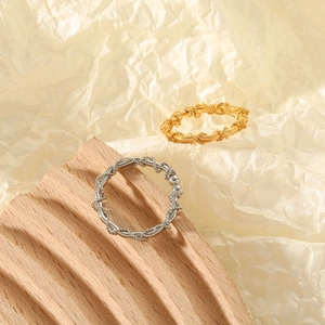 Detailed view of French twist wheat spike rings in gold and silver steel finishes