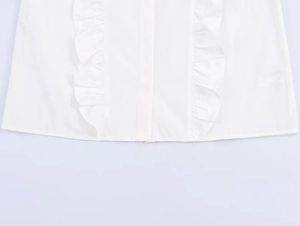 Detail of white poplin shirt showing symmetrical ruffle trim and clean hem stitching