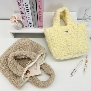 Detailed close-up of fluffy plush tote bags in cream and brown with soft texture