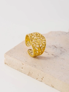 Detailed close-up of golden stainless steel open ring with floral hollow-out pattern