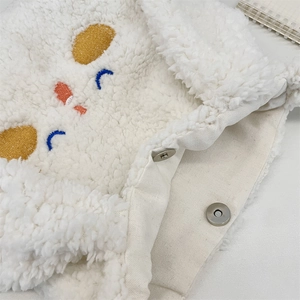 Dettaglio della borsa in peluche con morbida texture e chiusura magnetica in metallo