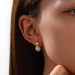 Detail von 18k vergoldeten Kugelohrringen mit Pavé-Kristallen an elegantem Damenmodell