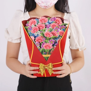 Close-up of 3D pop-up greeting card featuring a red bouquet with carnations and a gold bow