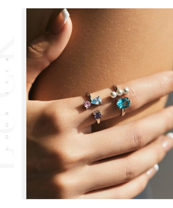Close-up of S925 silver rings set with colorful crystals and pearls on fingers