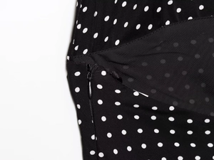 Macro detail of black polka dot fabric with seamless invisible zipper for women's dress