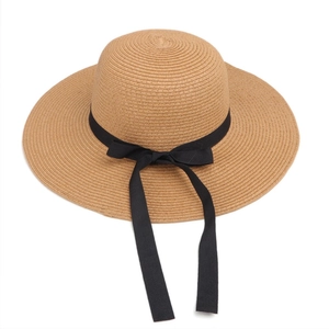 Close-up of finely woven straw sun hat texture with elegant black ribbon bow detail