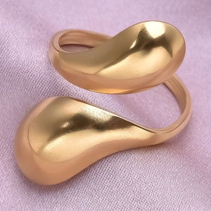 Close-up of a polished gold irregular water drop ring on a purple silk textured background