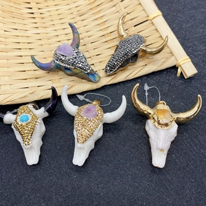 Set mit fünf Strass-Bullenkopf-Anhängern und Natursteinen auf schwarzem Hintergrund