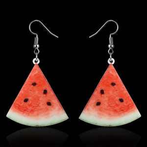 Macro shot of realistic watermelon slice earrings with red pulp on a black background