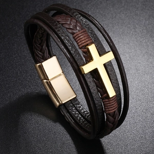 Detail of multi-layer braided leather bracelet with golden cross and magnetic clasp