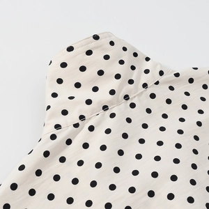 Close-up of polka dot jacket collar and shoulder seam with detailed woven texture