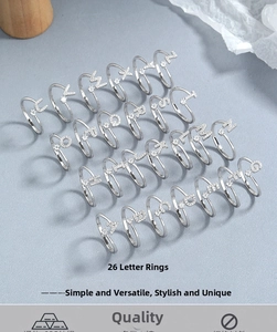 Nahaufnahme von 26 Buchstaben-Ringen aus 925er Sterlingsilber mit Zirkonia-Steinen besetzt