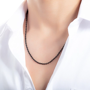 Close-up of minimalist black plated stainless steel chain necklace on a white shirt