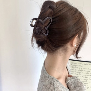 Detail of dark brown butterfly hair claw clip with glossy resin finish for daily styling